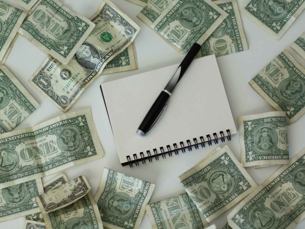 paper money on table surrounding a notebook