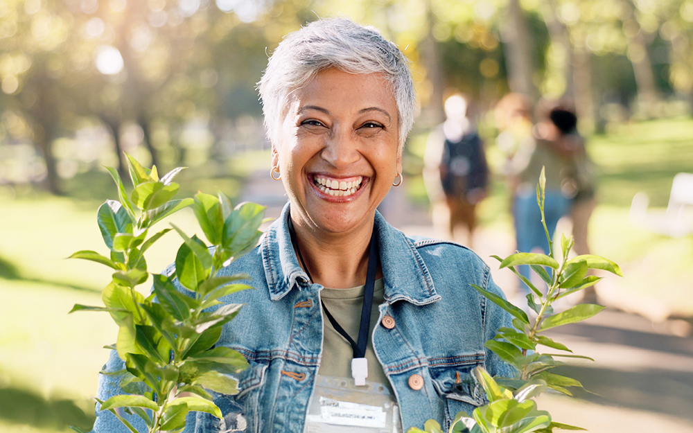 lady smiling holding a sapling