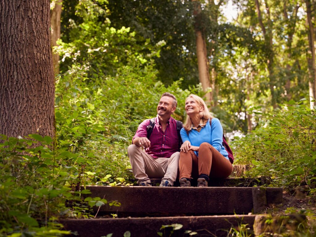 Mature couple in countryside hiking along path